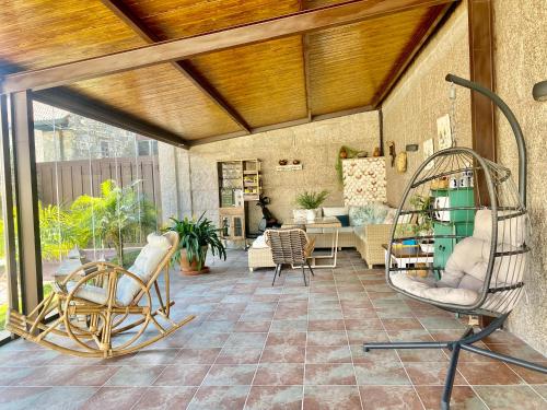 un patio con sillas y un columpio en una habitación en Villaprado, en Cambados