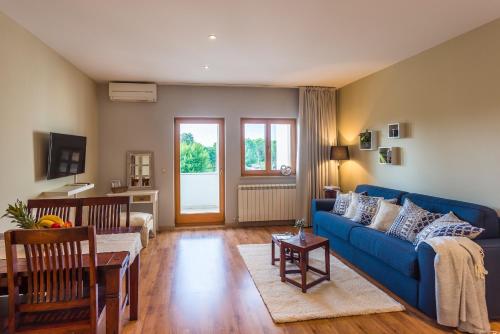 - un salon avec un canapé bleu et une table dans l'établissement Residence Antonio - Deluxe Apartments & Rooms, à Rovinj