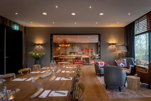 a restaurant with a long table and a dining room at Badhotel Rockanje in Rockanje