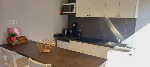 uma cozinha com armários brancos e uma bancada em Studio "Coeur du Lac" em Vielsalm
