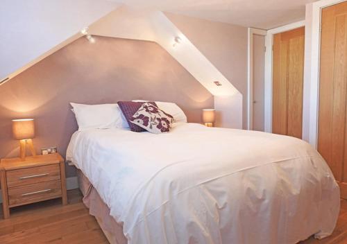 1 dormitorio con 1 cama blanca grande y ático en Coach House en Gosport