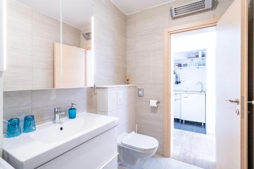 a white bathroom with a sink and a toilet at Stay U-nique Studio apartment in Orašac in Orasac
