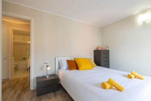 a bedroom with a large white bed with yellow pillows at Salomone - Mecenate District in Milan