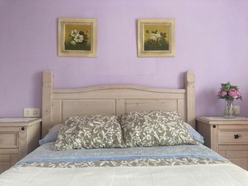 een slaapkamer met een bed met twee foto's aan de muur bij APARTAMENTO VALDEMAR PLAYA - WiFi & Aparcamiento in El Puerto de Santa María
