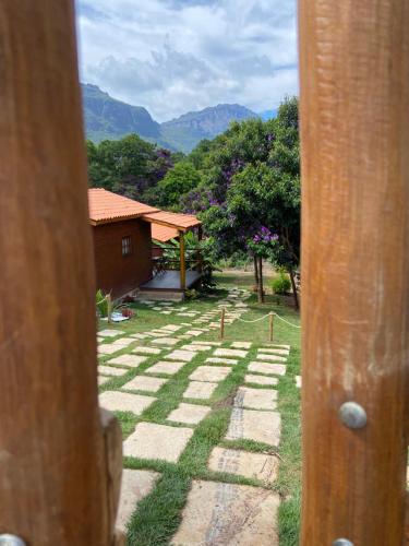 a view of a yard with a house in the background at Chalés Vila Do Vale in Vale do Capao