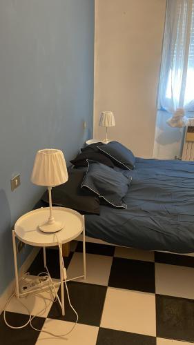 ein Schlafzimmer mit einem Bett und zwei Tischen mit Lampen in der Unterkunft L’appartamento di Mango e Pistacchio in Segrate