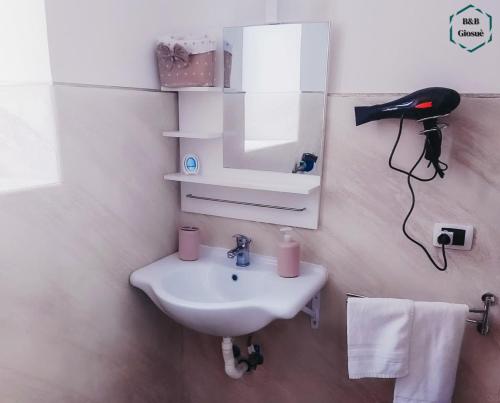 a bathroom with a white sink and a mirror at B&B Giosuè in Naples