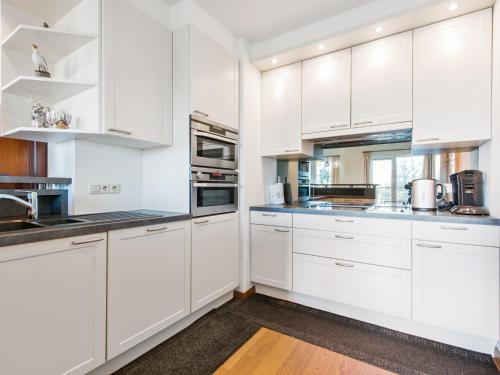 uma cozinha branca com armários e electrodomésticos brancos em Jachthaven II 3 bedrooms on floor 2 em Blankenberge