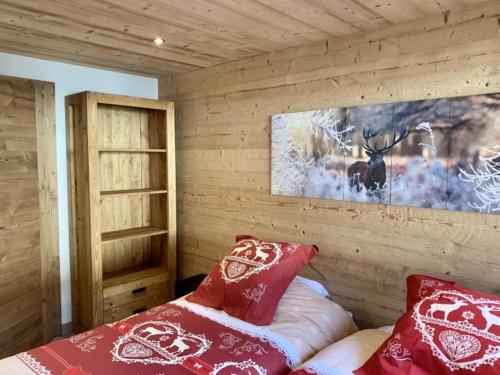 Zimmer mit einem Bett und zwei roten Kissen in der Unterkunft Spacious apartment in Chatel with ski-storage in Châtel
