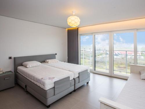 ein Schlafzimmer mit einem großen Bett und einem großen Fenster in der Unterkunft Appartement 1 bedroom with parking at Darwin II 0901 on floor 9 in Middelkerke
