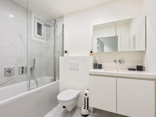 uma casa de banho branca com um WC e um lavatório em Costa Brava - Appartement 4 bedrooms - floor 9 em Blankenberge
