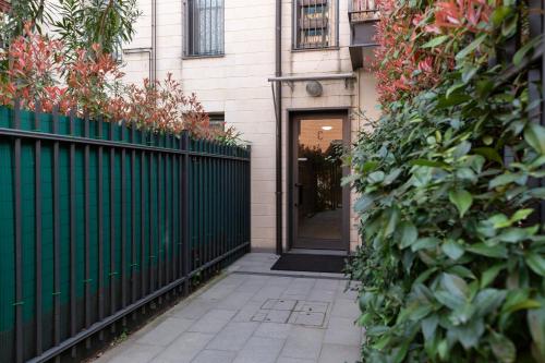 a door to a house with a green fence at Salomone - Mecenate District in Milan