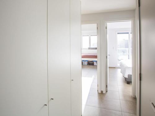 Ein weißes Zimmer mit einem Schlafzimmer und einem Bett. in der Unterkunft Appartment 2 bedrooms with garage at Les Amiraux 0701 on floor 7 in Middelkerke