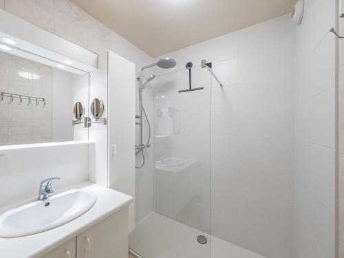 ein weißes Bad mit einer Dusche und einem Waschbecken in der Unterkunft Appartment 2 bedrooms at De Ra 0101 on floor 1 in Middelkerke