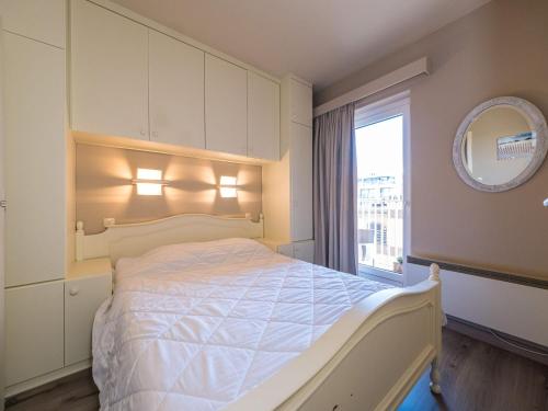 um quarto com uma cama com um espelho e uma janela em Appartement 1 bedroom at Stella 0602 on floor 6 em Middelkerke