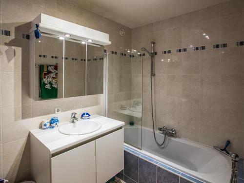 a bathroom with a sink and a shower and a tub at Duplex apartment near the center in Middelkerke