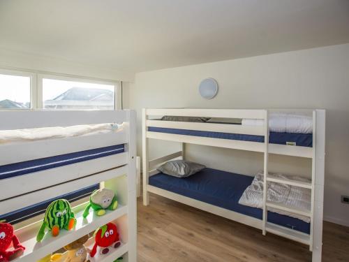 two bunk beds in a room with wooden floors at Luxury holiday home by the sea in Middelkerke