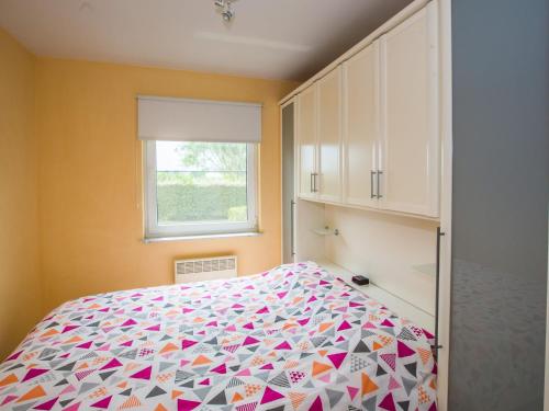 1 dormitorio con 1 cama con colcha colorida en Golf Azur Nice 0003 - Appartement 1 bedroom garage - floor 0, en Middelkerke