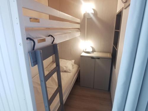 Cette petite chambre comprend des lits superposés et un bureau. dans l'établissement Studio 26m² lumineux, balcon sud, pied des pistes, 3-4 pers, commerces sur place - FR-1-181-2587, à Aime La Plagne