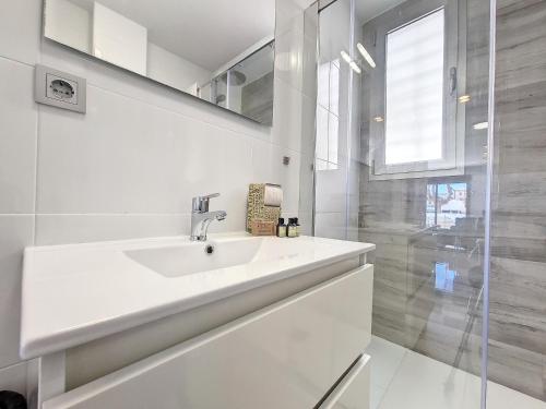 ein weißes Badezimmer mit Waschbecken und Dusche in der Unterkunft Los Alcazares Villa - 9509 in Los Alcázares
