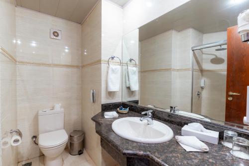 a bathroom with a sink and a toilet and a mirror at Life Resorts Coral Hills Beach & SPA in Quseir