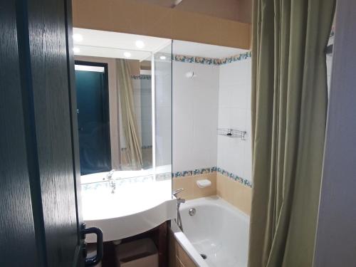 uma casa de banho com uma banheira, um lavatório e um espelho. em Appartement Plagne Soleil, 2 pièces, 5 personnes - FR-1-181-2623 em La Plagne Tarentaise