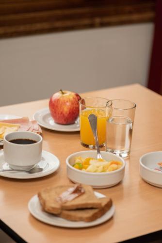 a table with plates of food and drinks and an apple at El Prado in Neuquén