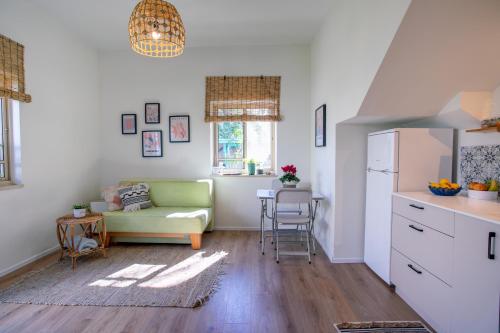 een woonkamer met een groene bank en een keuken bij lotus beach house in H̱adera