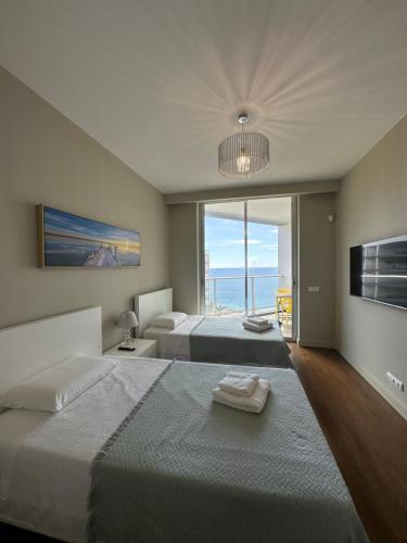 a bedroom with two beds and a view of the ocean at Madeira Palace Residences in Funchal