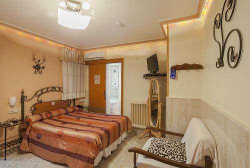 a bedroom with a bed and a tv on the wall at Pension San Jose in Bullas