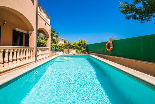 a swimming pool in front of a house at Delicias in Alcudia