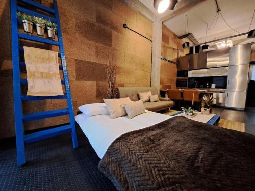 een slaapkamer met een bed en een blauwe ladder bij VibesCoruña - Loft Industrial Comercio in A Coruña