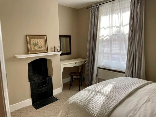 1 dormitorio con chimenea, 1 cama y ventana en St. John’s hill - with parking, en Shrewsbury