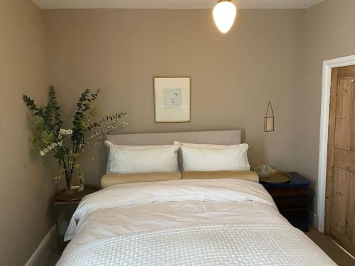 um quarto com uma cama grande e lençóis brancos em St. John’s hill - with parking em Shrewsbury