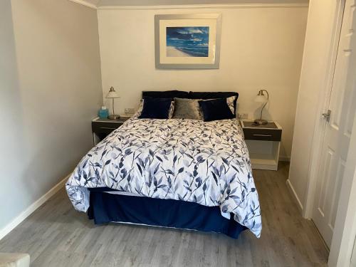 1 dormitorio con 1 cama con edredón azul y blanco en Garden lodge en Allesley