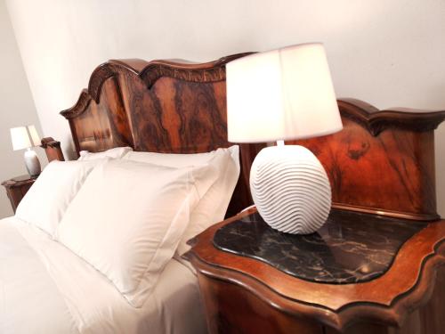 a bed with a table with a lamp on it at Ca' Mazzega in Murano