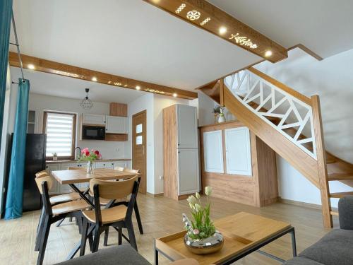 a living room and kitchen with a table and a staircase at Stylove Domki Bańska Niżna Domki z Jacuzzi in Bańska Niżna