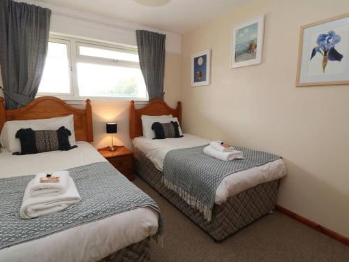 Gunnislake的住宿－Cheerful spacious 2 bedroom holiday home St Anns 12，一间卧室设有两张床和窗户。