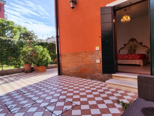 a porch with a checkered floor and a bed on a building at Ca' Mazzega in Murano