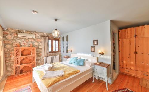 a bedroom with a large white bed and a stone wall at Kale Lodge - Adult Only + 15 in Kas
