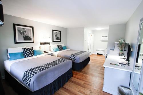 a hotel room with two beds and a flat screen tv at Colonial Inn Seekonk in Seekonk