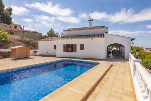 a villa with a swimming pool in front of a house at Villas Guzman - Matisse in Moraira