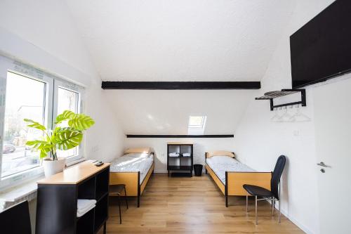 ein Zimmer mit zwei Betten und einem Schreibtisch in der Unterkunft Häusliches Loft Wohnung Apartment im Herzen von Ratingen in Ratingen