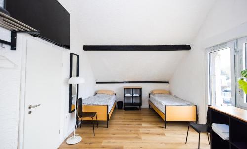 a room with two beds and a table and chairs at Häusliches Loft Wohnung Apartment im Herzen von Ratingen in Ratingen