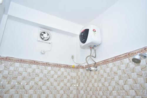 a shower in a bathroom with a tile wall at Jaldapara Binaychapa homestay in Mādāri Hāt