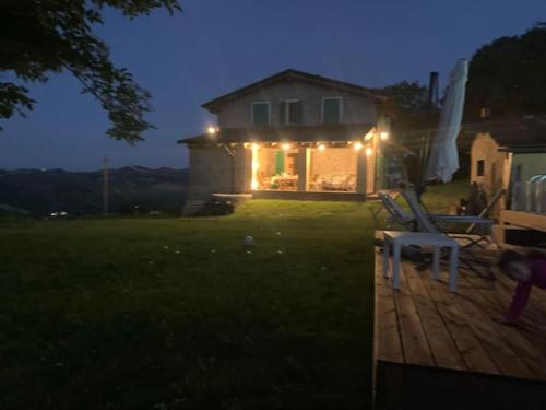 a house with lights on the back of a yard at Casale IL SAMBUCO sui colli bolognesi in San Lazzaro di Savena