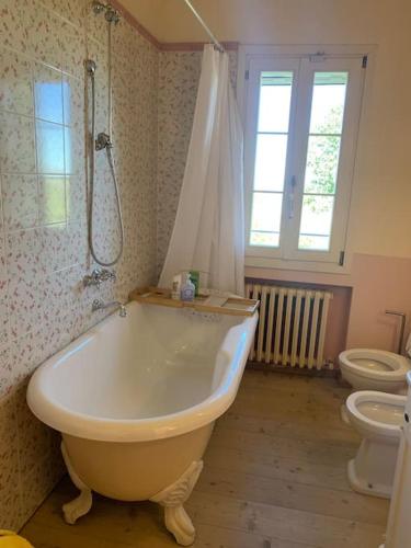 a bathroom with a bath tub and a toilet at Casale IL SAMBUCO sui colli bolognesi in San Lazzaro di Savena