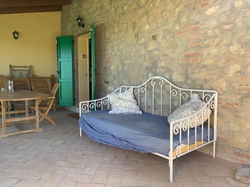 a metal bed sitting on a patio with a table at Casale IL SAMBUCO sui colli bolognesi in San Lazzaro di Savena