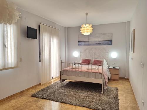 sypialnia z łóżkiem i żyrandolem w obiekcie Amplio y Moderno Apartamento Lorenzo Ferreira w Kordobie