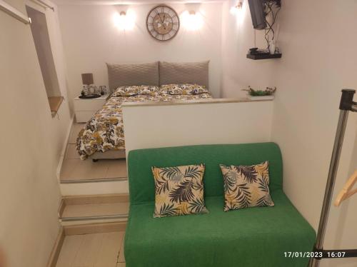 a small bedroom with a bed and a green couch at Montesanto House Palermo in Palermo